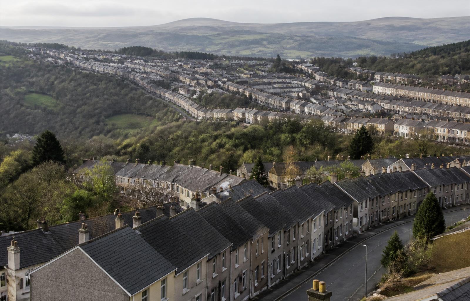 Traditional South Wales valleys town of terraced houses stepping up the hillside beneath distant mountains